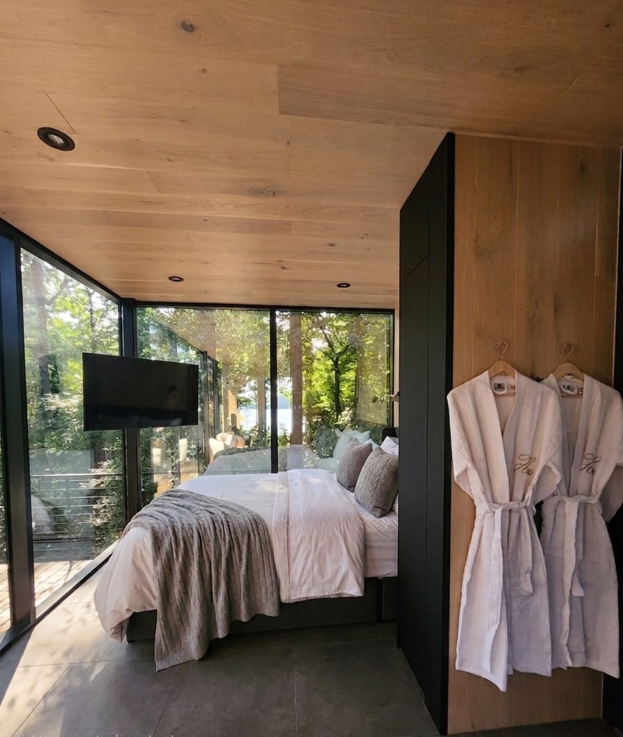 Bedroom with His & Hers robes and a glimpse of the lake