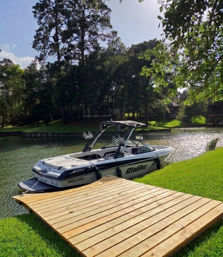 Wakeboard boat moored at the private wooden dock on Lake Livingston